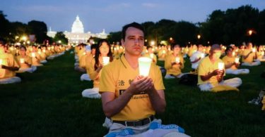Para praktisi Falun Gong dalam acara nyala lilin untuk mengenang para praktisi Falun Gong yang meninggal karena penganiayaan oleh Partai Komunis Tiongkok, di National Mall, Washington